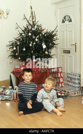 Brothers Sitting Under Christmas Tree in the Uk Stock Photo