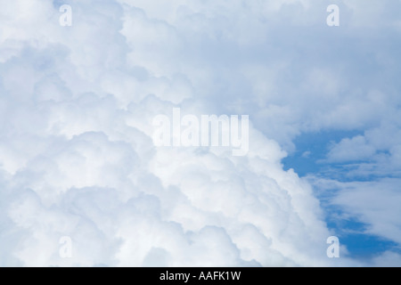 Aerial photograph of white clouds and blue sky taken from passenger window from jet airplane aircraft aeroplane 30,000 feet Stock Photo