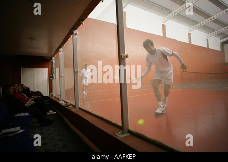 Real tennis players in action viewed from the hazard back wall side of the court, Essex England, UK Stock Photo