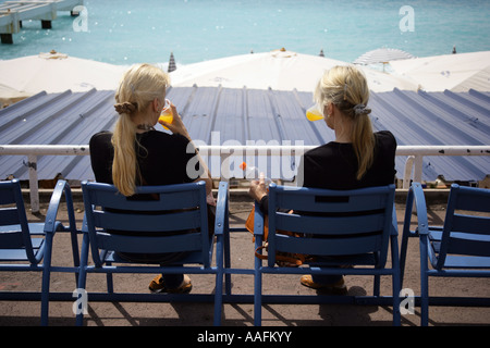Twin sisters drinking orange juice on the seafront, Promenade des Anglais, Nice France. EDITORIAL USE ONLY Stock Photo
