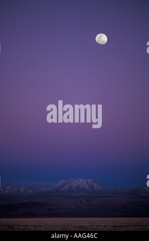 Moonrise Salar de Atacama Atacama Desert Chile Shades of pink and purple fill the air illuminate the surrounding peaks Stock Photo