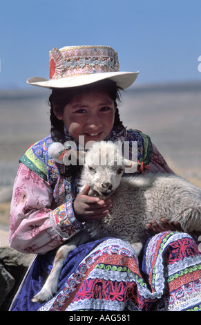 Quechua boy in distinctive tribal costume with a lamb Near Chivay Colca Canyon Southern Peru South America Stock Photo