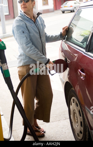 woman in a garage filling her  car with unleaded petrol, UK Stock Photo