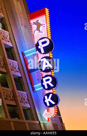 Colorful brightly lit neon parking sign at dusk Stock Photo