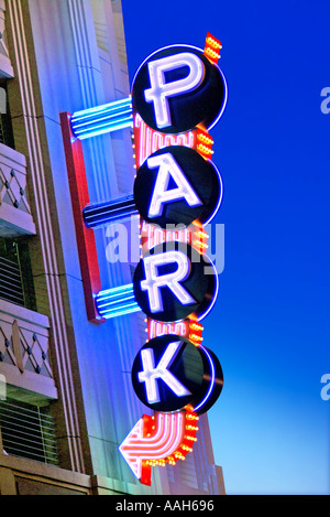 Colorful brightly lit neon parking sign at dusk Stock Photo