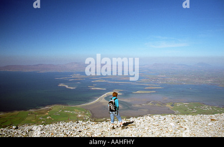 A walker looks out over Clew Bay ofrom the summit of Croagh Patrick County Mayo Ireland Stock Photo