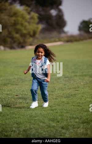 Girl 4 5 playing in field Stock Photo