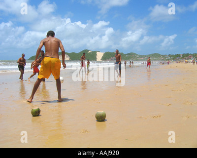 Young boys playing soccer on Praia do Ponta Negra beach in Natal Brazil using coconuts as goal posts Stock Photo