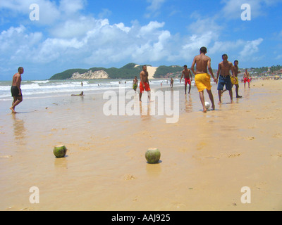 Young boys playing soccer on Praia do Ponta Negra beach in Natal Brazil using coconuts as goal posts Stock Photo