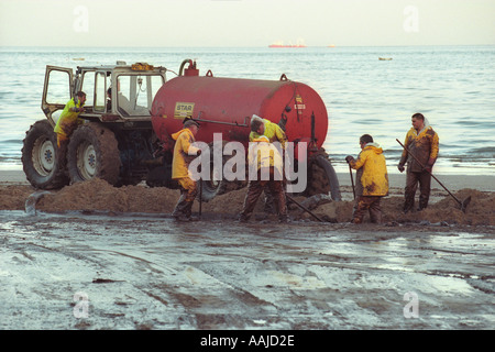 Contractors clean Tenby beach after tanker Sea Empress ran aground on rocks near Milford Haven spilling 72000 tonnes of oil Stock Photo