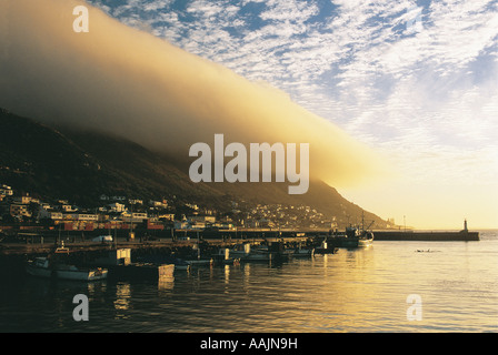Sunrise over fishing boats at Kalkbay Harbour Muizenberg Western Cape South Africa Low lying clouds hang over Table Mountain