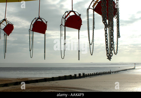 Sea side fun fair before start of day with breakwater in the background Stock Photo