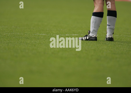 close up of football players feet stood still with black boots white socks Stock Photo