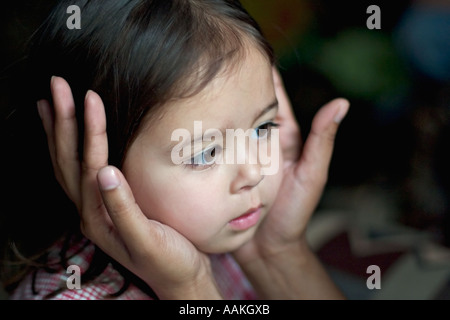 Mother holds her daughter’s face in her hands Stock Photo