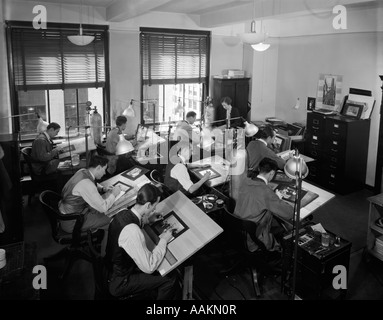 1930s COMMERCIAL ARTISTS AT WORK IN STUDIO ON DRAFTING TABLES Stock Photo
