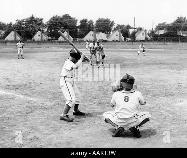 1960s TWO BOYS PITCHER AND CATCHER IN LITTLE LEague baseball uniforms  having a conversation on the pitcher's mound - b14306 HAR001 HARS B&W  PITCHER CATCHER RECREATION MOUND DIRECTION ON THE ATHLETES BALL