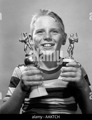 1950s 1960s SMILING BOY HOLDING TWO BASEBALL TROPHIES TROPHY AWARD LITTLE LEAGUE Stock Photo