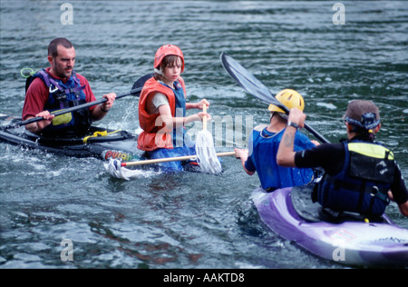 Cub Scouts aged 10 to 12 years play mop jousting in canoes on River Thames nr London england uk britain europe eu Stock Photo