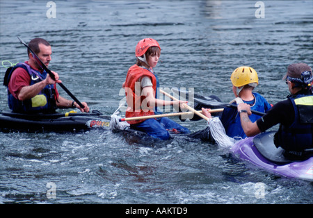 Cub Scouts aged 10 to 12 years play mop jousting in canoes on River Thames nr London england uk britain europe eu Stock Photo