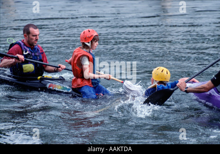 Cub Scouts aged 10 to 12 years play mop jousting in canoes on River Thames nr London england uk britain europe eu Stock Photo