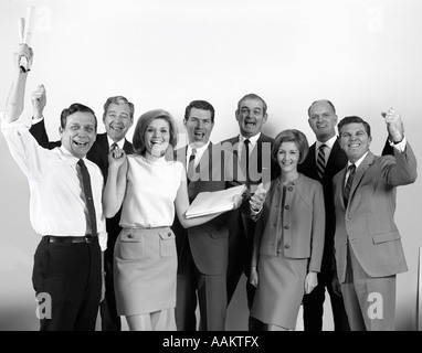 1970s WHITE COLLAR OFFICE WORKERS MEN AND WOMEN CHEERING LOOKING AT CAMERA Stock Photo