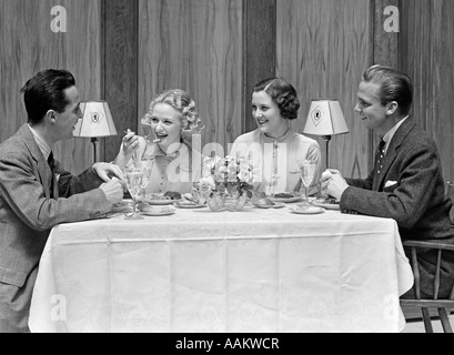 1930s 1940s TWO COUPLES DINING AT RESTAURANT TABLE Stock Photo