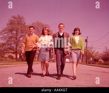 1960s TWO TEEN COUPLES WALKING TOWARDS CAMERA LOOKING AT CAMERA Stock Photo