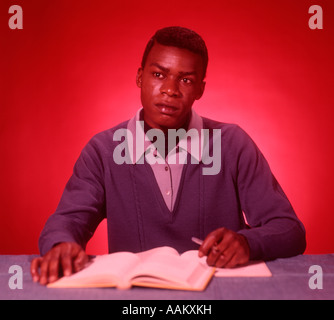 1960s AFRICAN AMERICAN STUDENT STUDYING TEXTBOOKS Stock Photo