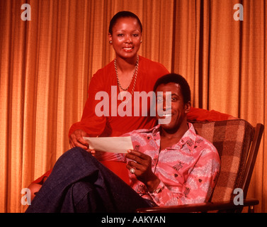 1970s AFRICAN AMERICAN COUPLE SMILING HOLDING CHECK Stock Photo