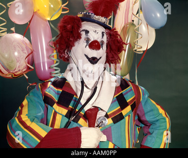 1960s FAT OVERWEIGHT CLOWN LISTENING TO HIS HEART WITH A MEDICAL STETHOSCOPE HEALTH Stock Photo