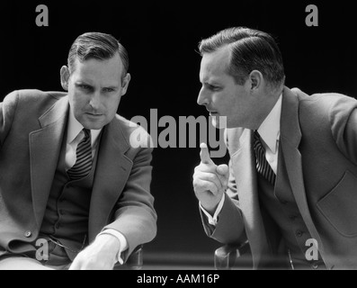 1930s 1940s BUSINESSMAN TALKING SERIOUSLY TO HIMSELF OR HIS TWIN ALTER EGO Stock Photo