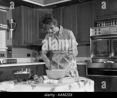 1960s WOMAN HOUSEHOLD PREPARE FOOD MIX KITCHEN Stock Photo