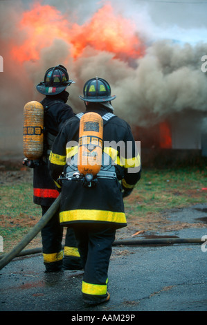 FIREMEN SPRAYING WATER ON FIRE Stock Photo