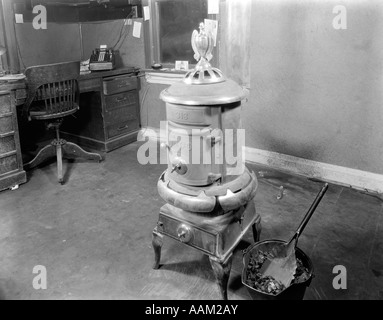 1920s COAL STOVE HEATER IN BUSINESS OFFICE Stock Photo