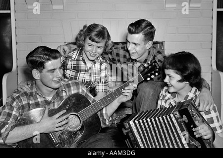 1950s MUSIC QUARTET BAND TWO COUPLES TEEN BOYS GIRLS SINGING PLAYING GUITAR & ACCORDION WEARING PLAID SHIRTS Stock Photo