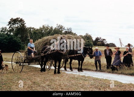 PEASANTS FARMERS MEN WOMEN OLD FASHIONED METHODS HORSE DRAWN HAY WAGON IN FIELD HARVEST CENTRAL FRANCE Stock Photo