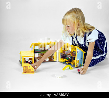 1970s BLONDE GIRL POLKA DOT DRESS PLAY WITH HINGED FOLDING DOLL HOUSE TOY GENDER ROLE PLAYING Stock Photo