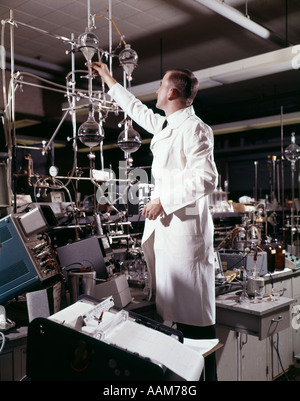 1960s LABORATORY TECHNICIAN CONDUCTING A TITRATION TEST SCIENCE EXPERIMENT ELABORATE PRECISION Stock Photo