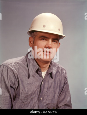 1960 1960s MAN WEARING HARD HAT WORKER WORKERS CONSTRUCTION MANUAL LABORER SAFETY HATS Stock Photo