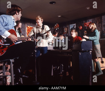 1970 1970s TEEN TEENAGE ROCK BAND TEENAGERS BOYS GIRLS SINGING MICROPHONES AMPLIFIERS GUITARS Stock Photo