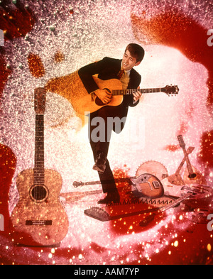 1970 1970s YOUNG MAN MUSICIAN PLAYING GUITAR ROCK MUSIC SURROUNDED BY SPECIAL EFFECTS GUITARS COLORS PSYCHEDELIC Stock Photo