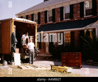 1970s 2 MEN WORKERS MOVERS LOAD UNLOAD BACK OF TRUCK MOVING VAN FURNITURE HOUSE NEW BRICK HOME PACK PACKING LOADING Stock Photo