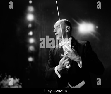 1960s 1970s PORTRAIT OF MAN IN WHITE TIE AND TAILS CONDUCTING AN ORCHESTRA IN SYMPHONY HALL Stock Photo