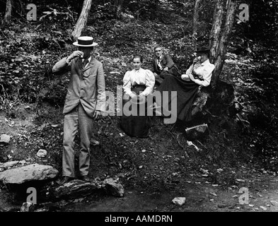 1890s 1900s GROUP OF TWO MEN & TWO WOMEN IN WOODS ONE MAN & ONE WOMAN DRINKING Stock Photo