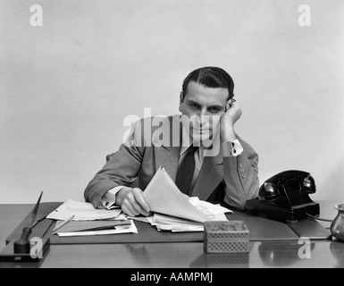 1940s TIRED OVERWORKED MAN BUSINESSMAN LEANING ON ELBOW LOOKING AT CAMERA Stock Photo