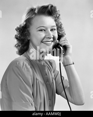 1940s YOUNG GIRL TALKING ON PHONE LOOKING AT CAMERA Stock Photo