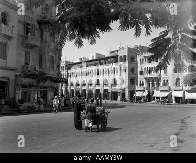 1920s 1930s STREET SCENE ARCHITECTURE IN ARAB STYLE VENDER PUSHING CART SUBURB OF CAIRO HELIOPOLIS EGYPT Stock Photo