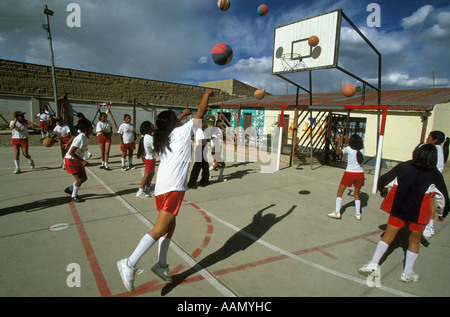 Girls shoot hoops on their school s outdoor courts during physical education class in Oruro Bolivia