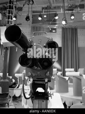 1960s CLOSE-UP OF TV CAMERA LENSES WITH STUDIO SET IN BACKGROUND Stock Photo