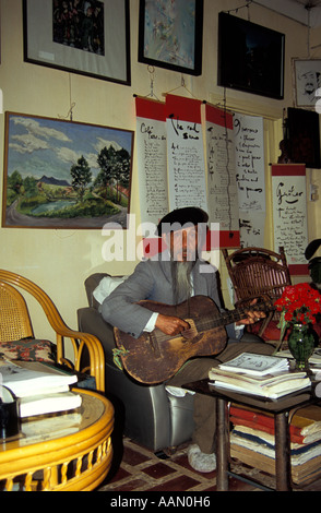 Bohemian poet Duy Viet strums guitar in his home/cafe/studio, Dalat, Vietnam Stock Photo